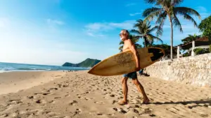 Man carries surfboard towards ocean